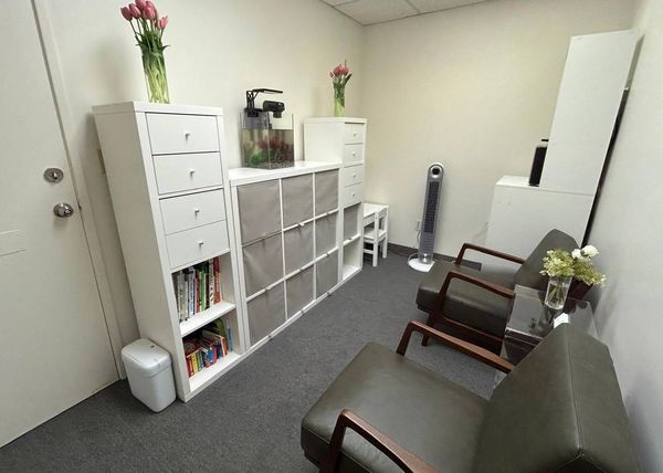 Welcoming waiting room for children and adolescents at Pediatric Neuropsychology Associates with comfortable seating, bookshelf, fish tank, and fresh flowers